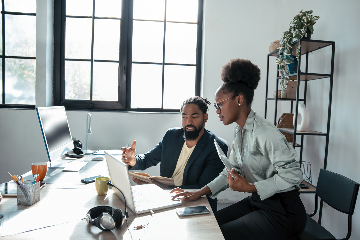 A Mentor Works With Their Mentee at a Computer Station