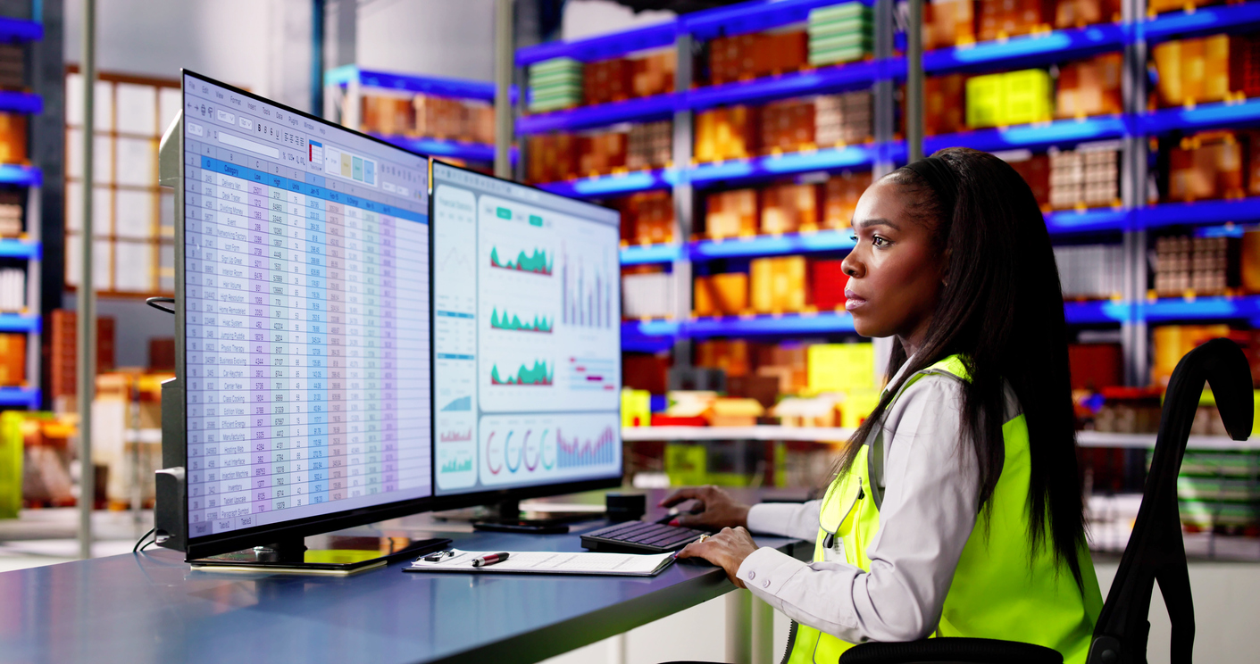 Supply Chain Professional Looking at Data on Two Monitors.