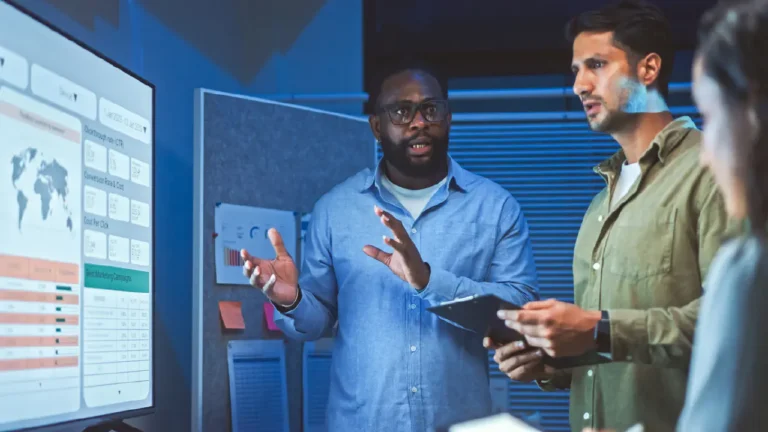 A Leader Collaborates With Other Colleagues Near a Presentation