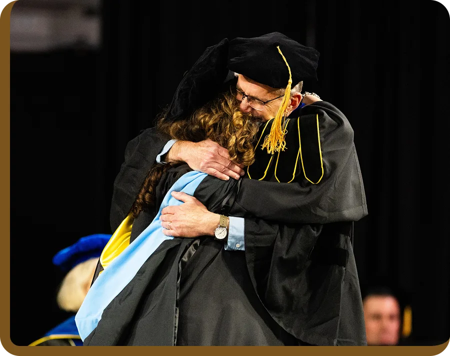 App State faculty hugging at graduation